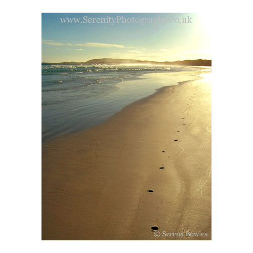 A lone set of footprints in the wet sand on a deserted beach. Western Australia.